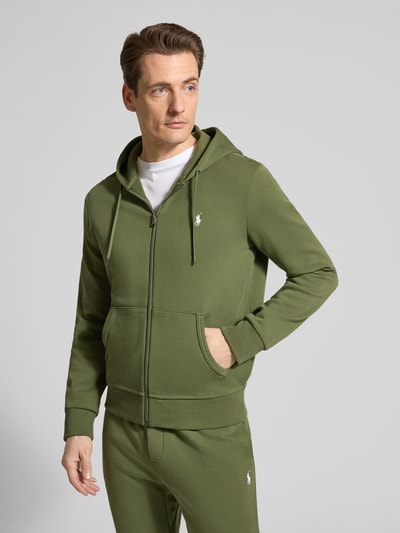 Männermodel trägt Regular Fit Sweatjacke aus Baumwoll-Mix von Polo Ralph Lauren in Optik: Unifarben, Grün, Ganzkörperansicht von vorne.