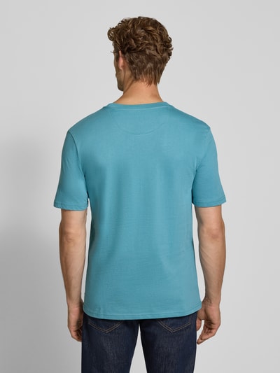 Männermodel trägt Regular Fit T-Shirt aus reiner Baumwolle von Scotch & Soda in Blau, glatte Textur, Rückenansicht, Ganzkörperansicht Rückansicht. Rückenlänge bei Größe M: 61 cm, Logo-Stitching, Rundhalsausschnitt.