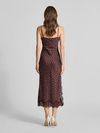 Frauenmodel trägt Cocktailkleid mit Spitzenbesatz Modell 'Jess' von Forever New, Midikleid, braun mit weißen Punkten, Material-Mix mit Viskose-Anteil, Gerader-Schnitt, Ganzkörperansicht Rückansicht. Rückenlänge bei Größe 36: 110 cm, Brustweite bei Größe 36: 34 cm.