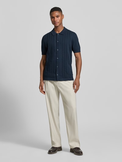 Männermodel trägt Slim Fit Poloshirt mit 1/2-Arm von OLYMP Level Five in Dunkelblau, Zopfmuster, Baumwoll-Mix, Ganzkörperansicht von vorne.