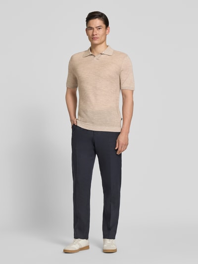 Männermodel trägt Slim Fit Poloshirt aus schurwolle met structuurpatroon van MAERZ Muenchen in beige, v-hals, heren, zuivere scheerwol, ruglengte bij maat 50: 72 cm, ganzkörperansicht von vorne.
