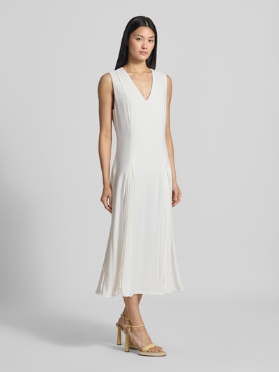 Frauenmodel trägt Regular Fit Midikleid mit Kellerfalten Modell 'Carneli' von Ted Baker in Creme mit V-Ausschnitt, ärmellos, Ganzkörperansicht von vorne, Damen Midikleid von Ted Baker, Rückenlänge 122 cm, Brustweite 45 cm.