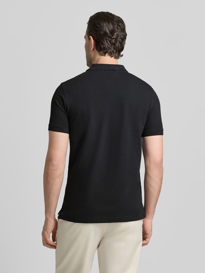 Männermodel trägt Slim Fit Poloshirt mit Logo-Stitching von MCNEAL in Schwarz, reine Baumwolle, Polokragen, Ganzkörperansicht Rückansicht.
