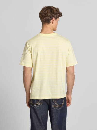 Männermodel trägt T-Shirt mit Streifenmuster und Label-Stitching von Jack & Jones in Gelb, Relaxed-Fit, Reine Baumwolle, Ganzkörperansicht Rückansicht.