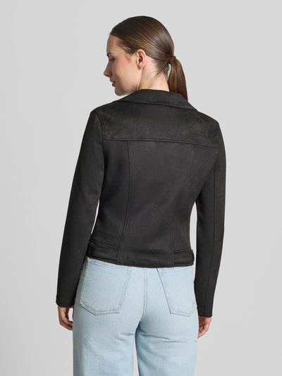 Modelka nosi czarną Regular Fit kurtkę ze sztucznej skóry z paskami na tułowiu model 'JOSE' od VERO MODA, gładka faktura, widok całej sylwetki z tyłu.