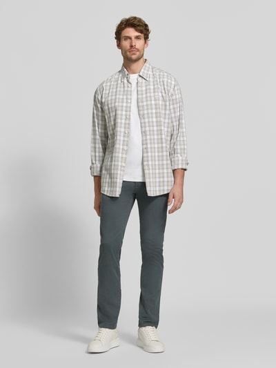 Männermodel trägt Slim Fit Chino aus Baumwoll-Mix Modell 'Chino Slim' von BOSS Orange, dunkles Grau, glatte Struktur, Ganzkörperansicht von vorne.