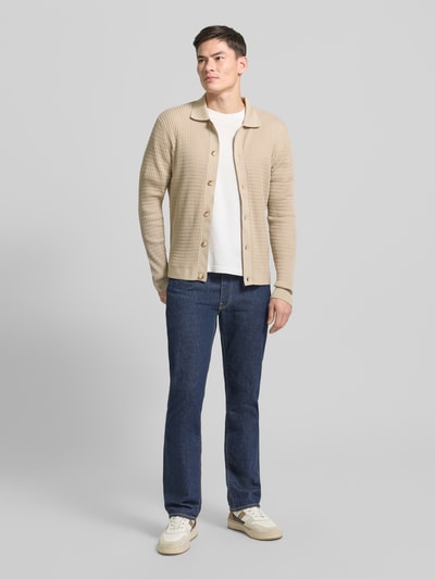 Męski model nosi Kardigan rozpinany z fakturowanym wzorem Model 'Yuris' od Cinque, mieszanka bawełny, krój slim fit, kołnierzyk polo, listwa guzikowa, długość tyłu 70 cm, długość rękawów 67 cm, widok całej sylwetki z przodu.