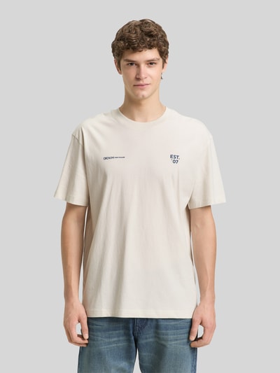 Männermodel trägt Relaxed Fit T-Shirt aus reiner Baumwolle von Tom Tailor Denim, Farbe Unifarben, Label-Print, Rundhals, Kurzarm, Ganzkörperansicht von vorne.