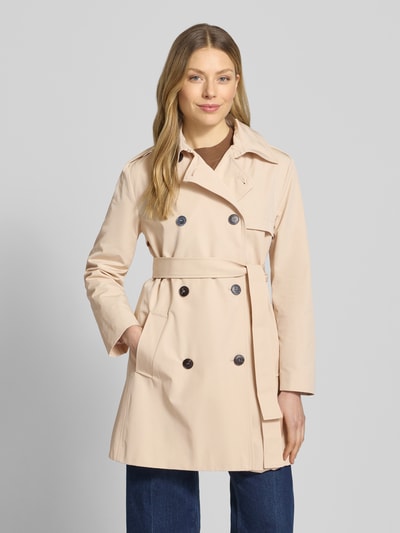 Frauenmodel trägt Regular Fit Trenchcoat mit Baumwoll-Anteil Modell 'ARIS' von MAX&Co., Optik: unifarben, doppelreihige Knopfleiste, Umlegekragen, Langarm, seitliche Eingrifftaschen, Gun Flap, Ganzkörperansicht von vorne.