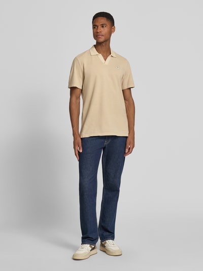 Männermodel trägt Regular Fit Poloshirt aus reiner Baumwolle von s.Oliver RED LABEL in Beige, unifarben, Piqué-Struktur, Ganzkörperansicht von vorne.