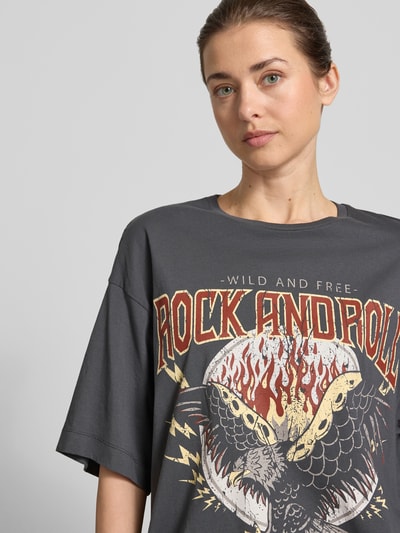 Frauenmodel trägt Oversized Damen T-Shirt aus reiner Baumwolle Modell 'LILIE' von Vero Moda in Optik: Unifarben mit Motiv-Print, Kurzarm, Nahaufnahme Oberkörper.