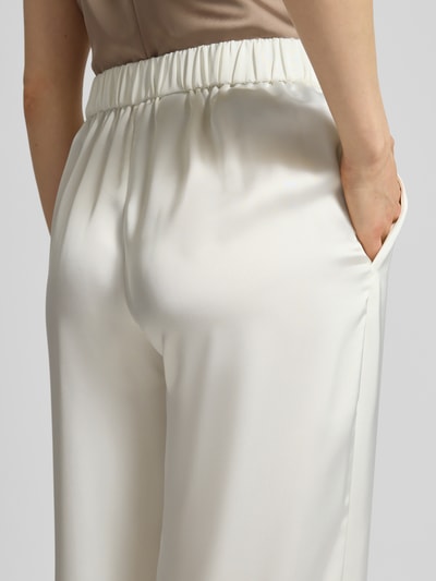 Frauenmodel trägt Slim Fit Weite Hose mit Schiebehaken und verdecktem Reißverschluss Modell 'HASELI-1' von HUGO, Optik: Unifarben, High-Waist, Materialverarbeitung: Satin, Nahaufnahme Rückansicht.
