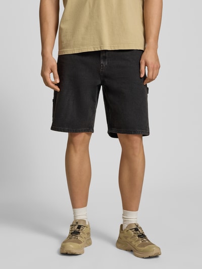 Männermodel trägt Bermudas mit seitlichen Eingrifftaschen und Gesäßtaschen von REVIEW, dunkler Baumwoll-Mix mit Stretch-Anteil, Ganzkörperansicht von vorne.