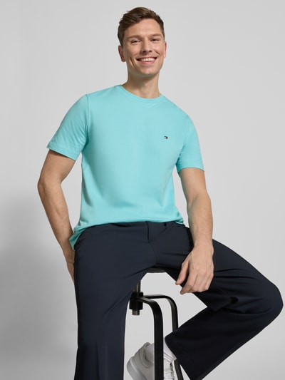 Männermodel trägt Regular Fit T-Shirt aus reiner Baumwolle von Tommy Hilfiger, Optik: unifarben, Logo-Stitching, Jersey, Ganzkörperansicht von vorne.