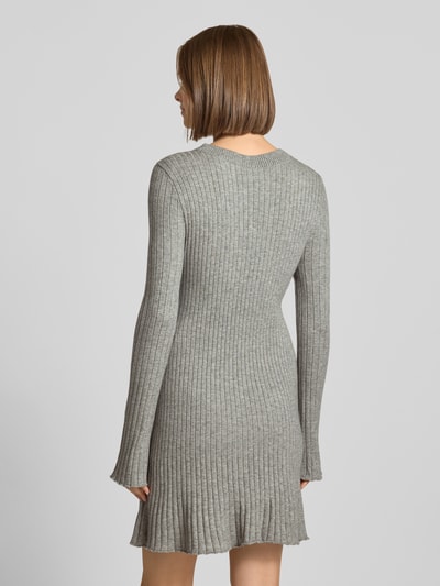 Vrouwenmodel draagt grijze tricotjurk van viscosemix, geribbelde textuur, model 'MICHELLA' van ONLY, vrijetijdsjurk, volledige achteraanzicht.