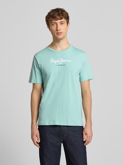 Männermodel trägt Regular Fit T-Shirt aus reiner Baumwolle Modell 'EGGO' von Pepe Jeans in Optik: Unifarben mit Label-Print, Ganzkörperansicht von vorne.