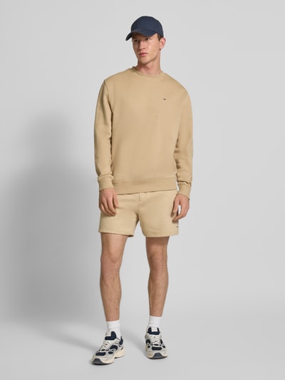 Männermodel trägt Regular Fit Sweatshirt aus Baumwoll-Mix von Tommy Jeans, Optik: Unifarben, Logo-Stitching, Sweat, Ganzkörperansicht von vorne.