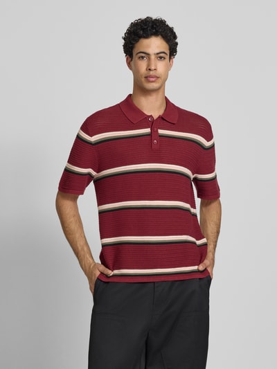 Männermodel trägt Regular Fit Poloshirt mit Streifenmuster Modell 'MAINE' von Jack & Jones aus reiner Baumwolle, Knopfleiste, Vorderansicht, Ganzkörperansicht von vorne.