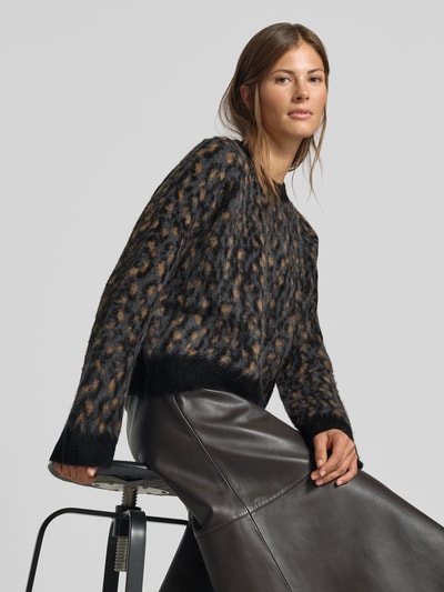 Frauenmodel trägt Relaxed Fit Pullover mit Alpaka-Anteil in Strick-Optik von MYON, Animal-Print, schwarze und braune Töne, Nahaufnahme Oberkörper.