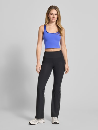 Modelka nosi Cropped Top mit integriertem Bustier von Fabletics, elastyczna mieszanka materiałów, dekolt na plecach, długość tyłu w rozmiarze L: 13 cm, krój krótki, widok całej sylwetki z przodu.
