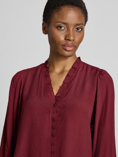 Frauenmodel trägt Regular Fit Bluse aus Viskose-Mix von Apricot, V-Ausschnitt mit Rüschen, Knopfleiste, bordeaux, Nahaufnahme Oberkörper.