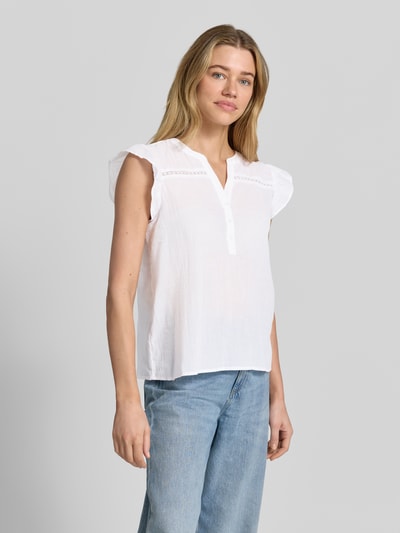 Modelka nosi Blusenshirt mit kurzer Knopfleiste Modell 'FABIANA' von Soyaconcept z bawełny, prosty krój, dekolt serafino, długość tyłu 55 cm, rozmiar S, białe, tekstura lekko fakturowana, przód, zdjęcie całej sylwetki