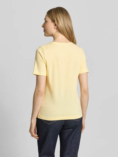 Frauenmodel trägt T-Shirt mit Rundhalsausschnitt von Christian Berg Woman in Gelb aus Reine Baumwolle, Regular-Fit, 1/2-Arm, Rückenlänge 60 cm, Ganzkörperansicht Rückansicht.
