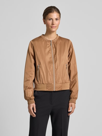 Frauenmodel trägt Jacke mit Rundhalsausschnitt und Reißverschlusstaschen von monari in Braun, Regular-Fit, glatte Textur, Ganzkörperansicht von vorne, Rückenlänge bei Größe 36: 52 cm, Schulterbreite: 46 cm, Brustweite: 53 cm, Ärmellänge: 57 cm.