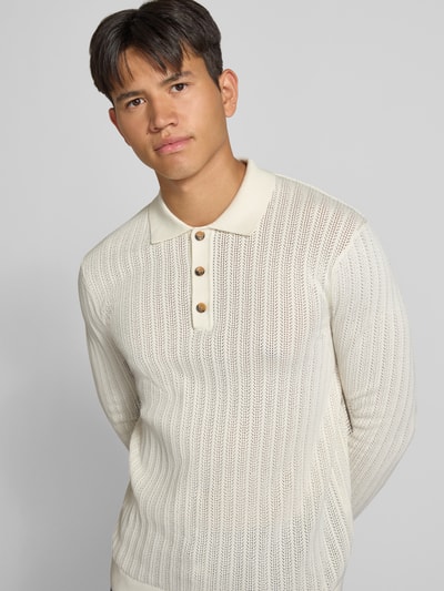 Männermodel trägt Regular Fit Poloshirt aus Baumwoll-Mix Modell 'MOON' von ONLY & SONS in Creme mit Rippstrickstruktur, Nahaufnahme Oberkörper.