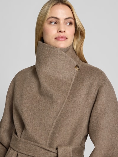 Frauenmodel trägt Kurzblazer aus Woll-Mix mit Bindegürtel von COMMA, warme Brauntöne, weiche Textur, Nahaufnahme Oberkörper. Damen Kurzblazer aus Woll-Mix mit Viskose-Anteil, Regular Fit, breiter Umlegekragen, Eingrifftaschen, Maße wie beschrieben.
