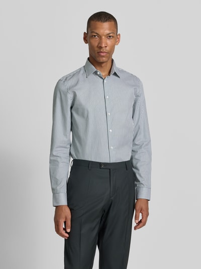 Männermodel trägt Slim Fit Business-Hemd mit Kentkragen von Jake*s, weiße und blaue Streifen, Reine Baumwolle, Knopfleiste, Sportmanschetten, abgerundeter Saum, Rückenlänge 78 cm, Schulterbreite 47 cm, Ärmellänge 66 cm, Ganzkörperansicht von vorne.