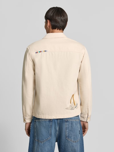 Männermodel trägt Regular Fit Overshirt mit Motiv-Prints- und -Applikationen von Scotch & Soda, helle Baumwolle, Rückenansicht, KI-modifiziertes Bild.