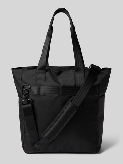 Produktfoto, Tote Bag mit Label-Detail Modell 'Richmond' von Carhartt Work In Progress, schwarze Oberfläche, Reißverschluss, seitliche Tasche, verstellbarer Schulterriemen, robuster Stoff, rechteckige Form, sichtbare Label-Applikation