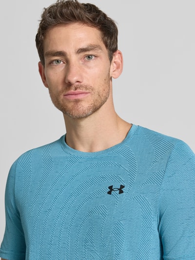 Männermodel trägt Funktionsshirt mit Logo Modell 'Vanish Seamless Novelty' van Under Armour in blauw met structuurpatroon, regular fit, ronde hals, ruglengte bij maat M 72 cm, Nahaufnahme Oberkörper.