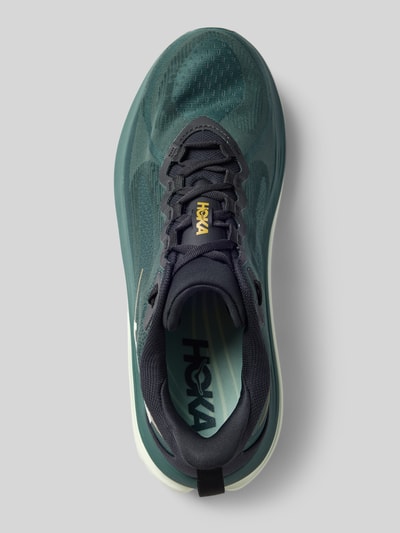 Produktfoto, Sneaker mit Label-Details und Schnürverschluss von HOKA in Grün-Blau, abgerundete Form, profilierte Sohle, Textil-Textur, Kontext: Herren Sneaker mit 6 cm Absatz, 7 cm Schafthöhe, 6 cm Schaftweite, Draufsicht