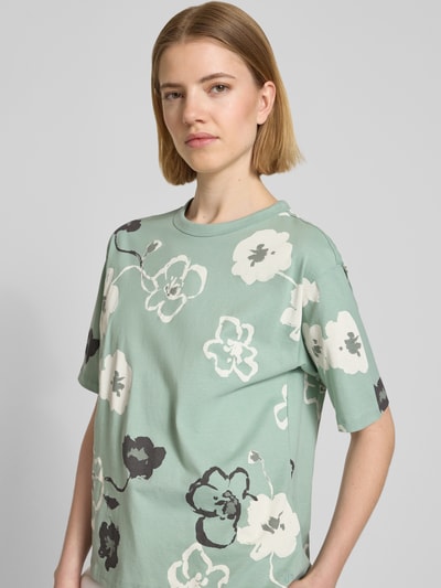 Frauenmodel trägt T-Shirt im Allover-Look mit Rundhalsausschnitt von JAKE*S STUDIO WOMAN, mintgrün, weiße und schwarze Blumen, reine Baumwolle, Regular Fit, Ganzkörperansicht von vorne.