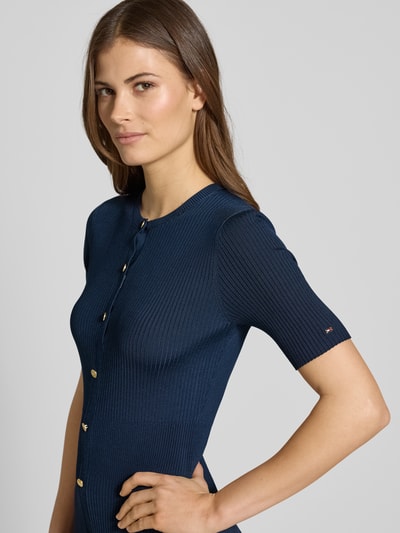 Frauenmodel trägt Eng anliegendes Freizeitkleid aus Viskose-Mix von Tommy Hilfiger, Optik: Unifarben, Passform, Midi-Länge, Rundhals, Logo-Detail, Zierknöpfe, Knopfleiste, Ärmelform: Kurzarm, Nahaufnahme Oberkörper.