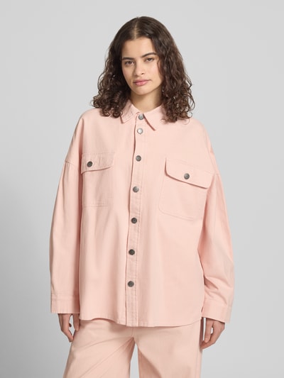 Frauenmodel trägt Oversized Hemdjacke mit Brusttaschen von Karo Kauer in Rosa, reine Baumwolle, Umlegekragen, Knopfleiste, Ganzkörperansicht von vorne.