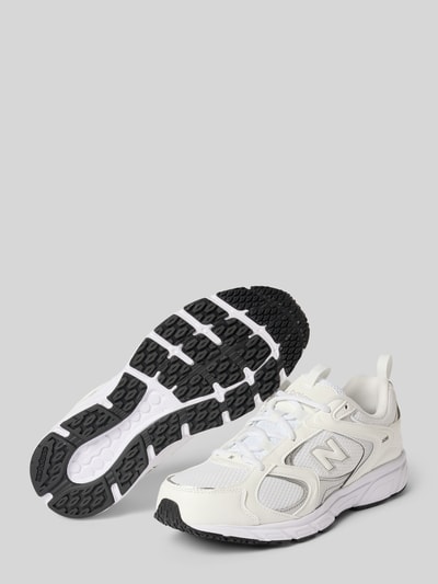 Produktfoto, Sneaker mit Logo-Detail Modell '408' von New Balance, weiße Oberfläche, schwarze profilierte Sohle, runde Form, Textilmix, Damensneaker, Schnürverschluss, leichter Schuh, Markenlogo, abgerundete Passform, Absatzhöhe 3 cm, Schafthöhe 7 cm, Schaftweite 8 cm