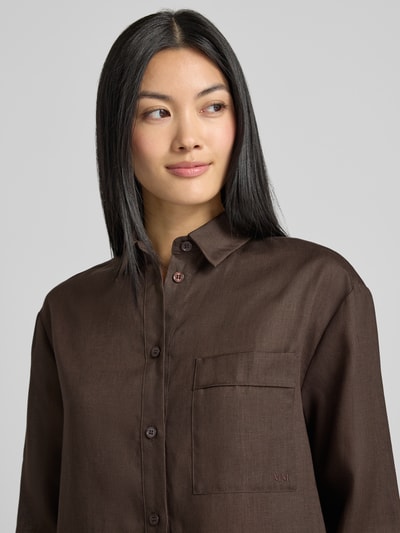 Vrouwenmodel draagt Regular Fit Leinenbluse met borstzak model 'FILO' van MM by Max Mara, puur linnen, hemdkraag, knoopsluiting, bruine tint, textuur met zichtbare linnenstructuur, borstzak links, detailopname bovenlichaam.