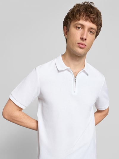 Männermodel trägt weißes Regular Fit Poloshirt mit Reißverschluss Modell 'AUSTIN' von Jack & Jones, Strukturmuster, Nahaufnahme Oberkörper.