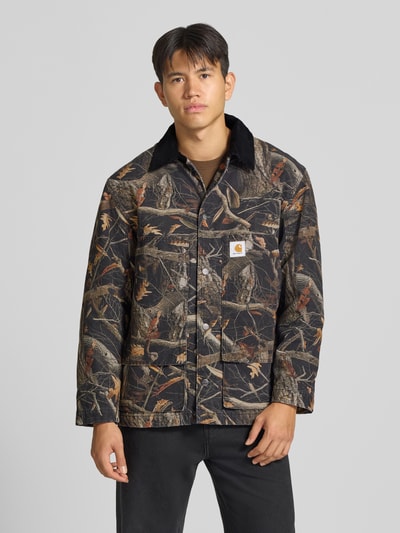 Männermodel trägt Jacke im Allover-Look mit Label-Detail Modell 'Lander' von Carhartt Work In Progress, Muster in Braun und Schwarz, Kentkragen, reine Baumwolle, Regular Fit, Ganzkörperansicht von vorne.