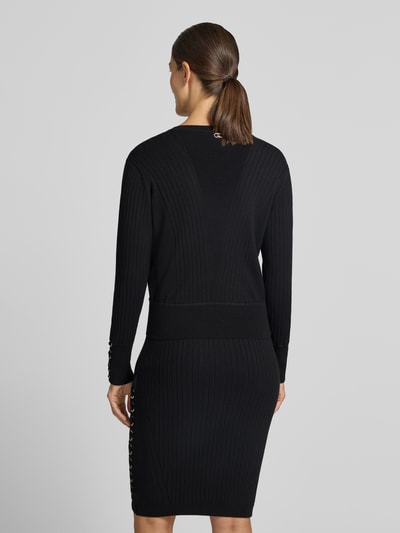 Vrouwenmodel draagt gebreide pullover uit viscosemix Model 'MAGLIA' van Liu Jo, smalle pasvorm, ribboorden, ruglengte maat S 54 cm, mouwlengte maat S 61 cm, zwarte kleur, geribde textuur, Ganzkörperansicht Rückansicht.