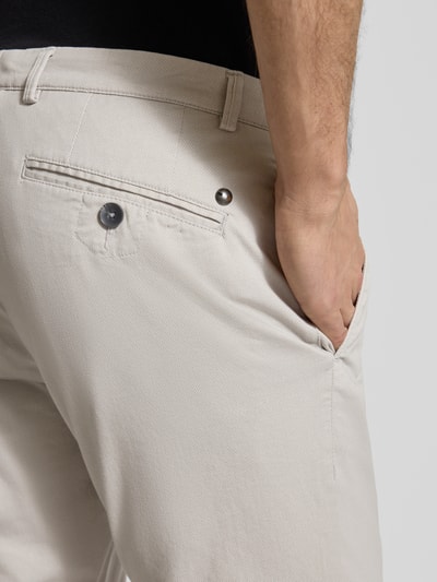 Mężczyzna nosi Fein strukturierte Chino mit Gesäßtaschen od bugatti, bawełniany materiał ze stretchem, krój regular fit, jasny beż, tekstura drobna, detal tylnej kieszeni, zbliżenie tylnej części.