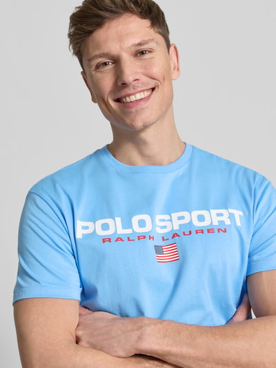 Männermodel trägt Relaxed Fit T-Shirt aus reiner Baumwolle von Polo Ralph Lauren in Hellblau mit Label Print, Nahaufnahme Oberkörper.