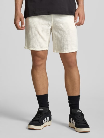 Männermodel trägt Shorts mit Strukturmuster Modell 'AIDEN' von Jack & Jones in Weiß, elastischer Bund, seitliche Taschen, Ganzkörperansicht von vorne.