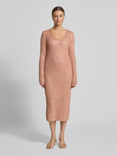 Frauenmodel trägt Slim Fit Midikleid mit Woll-Anteil von Marc Cain in Rosé mit Allover-Lochmuster und Pailletten, Ganzkörperansicht von vorne.