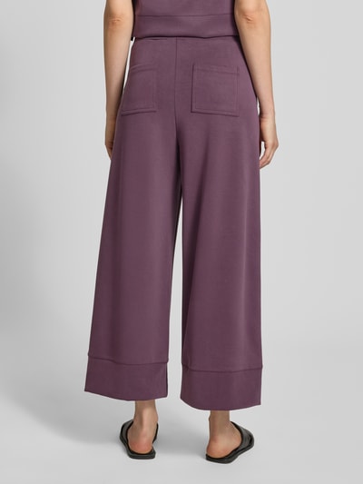 Kobieta prezentuje Wide Leg Sweatpants mit Eingrifftaschen od Rich & Royal, mieszanka modalu z dodatkiem streczu, elastyczny pas, wpuszczane kieszenie, długość wewnętrzna nogawki w rozmiarze S: 64 cm, widok całej sylwetki od tyłu.