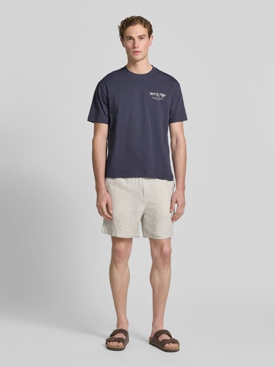 Męski model nosi Relaxed Fit T-Shirt aus reiner Baumwolle von Marc O'Polo, jednokolorowy, krój regular fit, nadruk z logo i motywem, okrągły dekolt, krótki rękaw, dżersej, czysta bawełna, całkowity widok z przodu