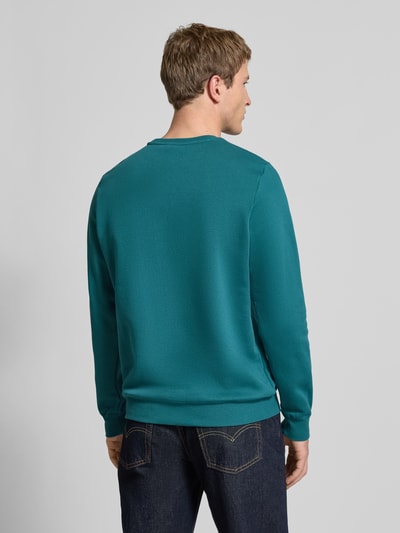 Mężczyzna nosi Regular Fit Sweatshirt mit Logo-Stitching od PUMA PERFORMANCE z mieszanki bawełny, okrągły dekolt, wykończenia elastyczne, długość tyłu 69 cm, długość rękawa 69 cm, widok całej sylwetki z tyłu.